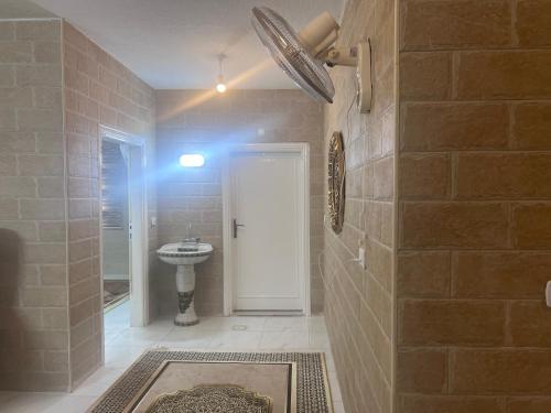 a bathroom with a sink and a toilet and a door at Ibbin hospitality house 2 in Ajloun