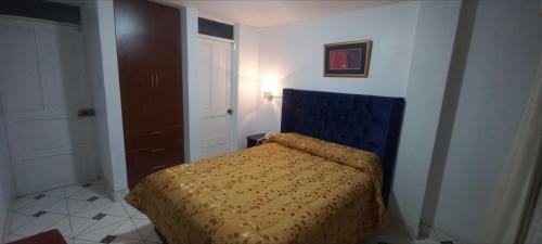 1 dormitorio con 1 cama con cabecero azul en HOTEL F0NTEs GLOBAL, en Tacna