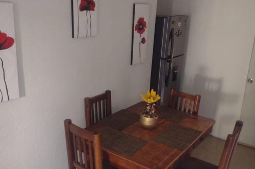 a dining room table with a vase of flowers on it at casa con vigilancia las 24hrs in Santa Cruz Tecamac