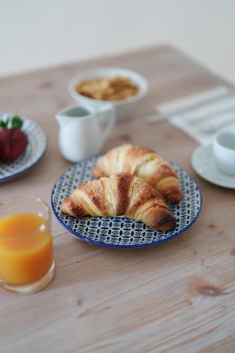 a table with two plates of croissants and orange juice at Villa Prota in Vico Equense