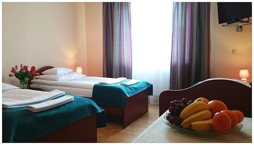 a hotel room with two beds and a bowl of fruit at GoGreen Hotel in Rząska