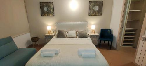 a bedroom with a large bed and a blue couch at Apartamento Mar&Pol in Palafrugell