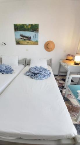 2 Betten in einem Zimmer mit einem Bild an der Wand in der Unterkunft Alkisti's seaside apartments in Pythagoreio