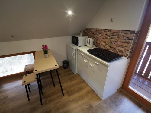 a small kitchen with a table and a microwave at Glamping APARTMA NA KOZOLCU 