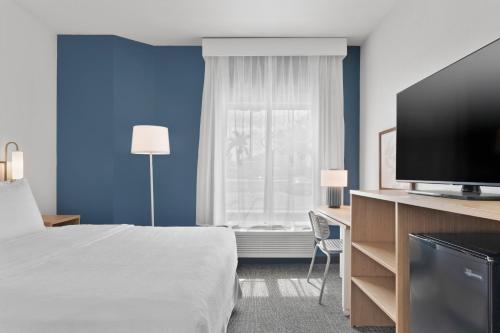a hotel room with a bed and a flat screen tv at Spark by Hilton Orlando near SeaWorld in Orlando
