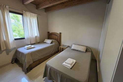 een kleine kamer met 2 bedden en een raam bij La Velez in Guaymallen