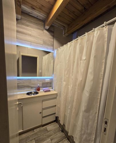 a bathroom with a shower curtain and a sink at La Velez in Guaymallen