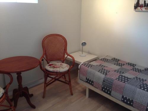 a bedroom with a bed and a table and chair at Rane Ladegaard in Ebeltoft