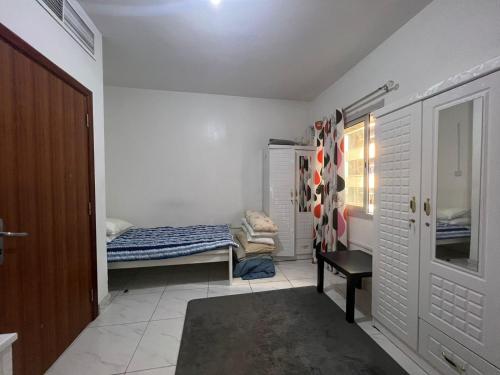 Kleines Zimmer mit einem Bett und einem Fenster in der Unterkunft Furnished Regular Room in shared Apartment in Abu Dhabi