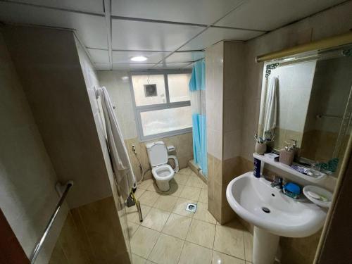 ein kleines Bad mit einem Waschbecken und einem WC in der Unterkunft Furnished Regular Room in shared Apartment in Abu Dhabi