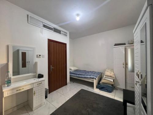 uma casa de banho com uma cama, um lavatório e um espelho. em Furnished Regular Room in shared Apartment em Abu Dhabi