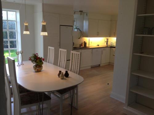 a kitchen with a table and chairs and a dining room at Rane Ladegaard in Ebeltoft