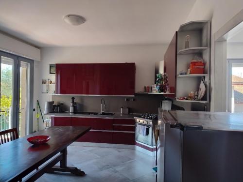 a kitchen with red cabinets and a wooden table at 5 Terre Italian Delight Red in La Spezia