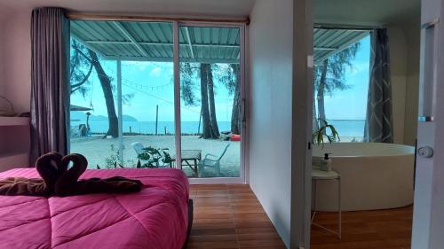 a bedroom with a view of the beach and a tub at Modtanoi Paradise Homestay in Ban Bu Lu