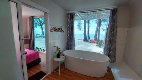 a bath tub in a bathroom with a view of the ocean at Modtanoi Paradise Homestay in Ban Bu Lu