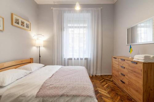 ein Schlafzimmer mit einem Bett, einer Kommode und einem Fenster in der Unterkunft 2 кім квартира подобово на вулиці Ткацькій 8, на 5 осіб - бічна Замарстинівської новобуд Авалон in Lwiw