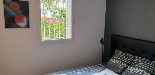 une chambre avec un lit et une fenêtre dans l'établissement Appartement T2 au port, Clim, Fibre, Terrasse, à Saint-Cyprien