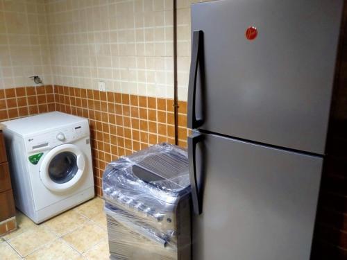 a kitchen with a refrigerator and a washing machine at 1 BHK Fully Furnished Flat in Sharjah