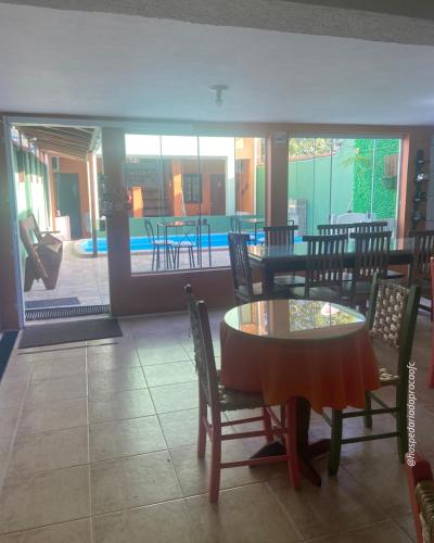 a dining room with a table and chairs and a pool at Hospedaria da Praça in Antonina