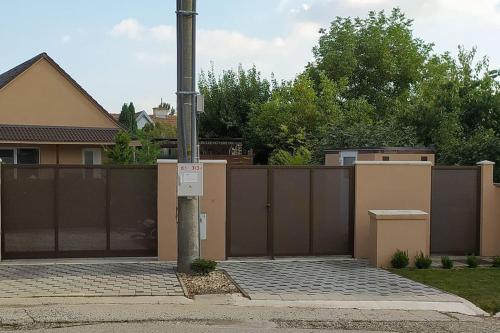 a fence with a pole in front of a house at Príjemné ubytovanie v plne vybavenom rodinnom dome in Trnava
