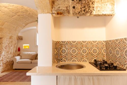 cocina con fregadero y sala de estar. en Tenuta Lavati, Santa Maria di Leuca, en Castrignano del Capo