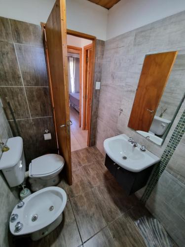 uma casa de banho com um lavatório, um WC e um espelho. em Terrazas de Estancia em Villa Carlos Paz