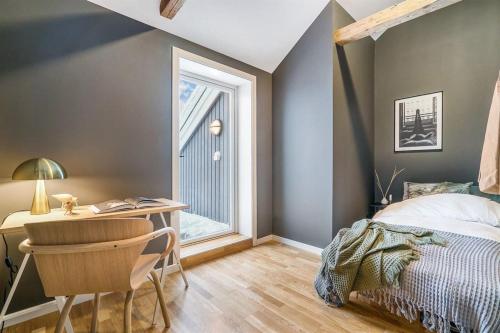 1 dormitorio con cama, escritorio y ventana en Sentral leilighet med 4 soverom, en Tønsberg