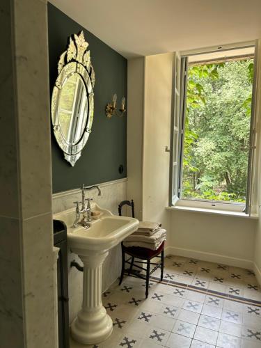 La salle de bains est pourvue d'un lavabo et d'une fenêtre. dans l'établissement Château La Bruguière, à Tornac