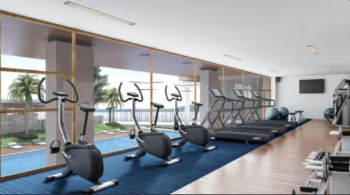 a gym with rows of exercise bikes and a pool at Condotel at Mesavirre Bacolod City in Bacolod