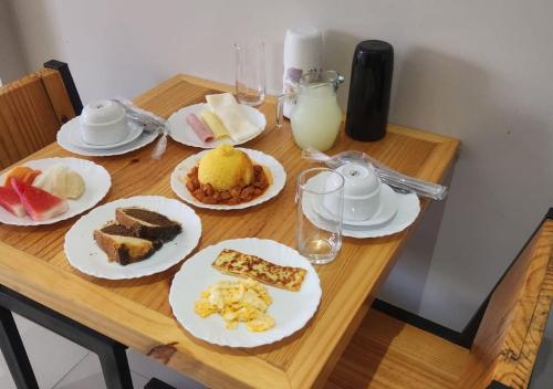 a wooden table with plates of food on it at BOB Suítes in Porto De Galinhas