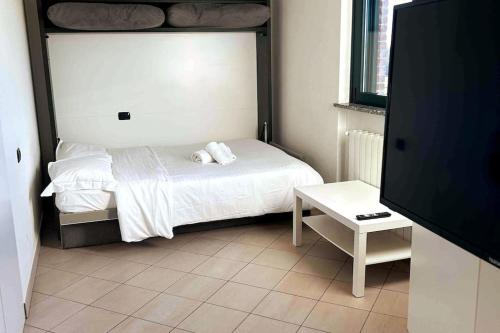een kleine slaapkamer met een bed en een tafel bij App 27 Parcheggio Privato - Accogliente Monolocale in Monza