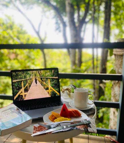 a laptop computer sitting on a table with a plate of food at Villas en el Bosque in Ojochal