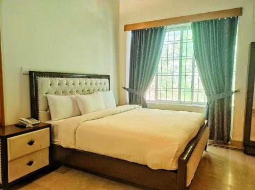 a bedroom with a large bed and a window at Baani Signature in Islamabad