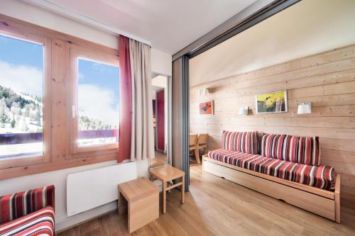 un salon avec un canapé et une fenêtre dans l'établissement Résidence Plagne Lauze - maeva Home - Studio 4 personnes avec parking - Sélection MAE-9200, à Mâcot La Plagne