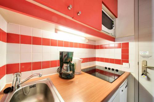 une cuisine avec des carreaux rouges et blancs sur le mur dans l'établissement Résidence Plagne Lauze - maeva Home - Studio 4 personnes avec parking - Sélection MAE-9200, à Mâcot La Plagne