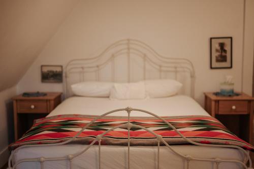 1 dormitorio con 1 cama blanca y 2 mesitas de noche en Gable House Bed and Breakfast Inn, en Durango