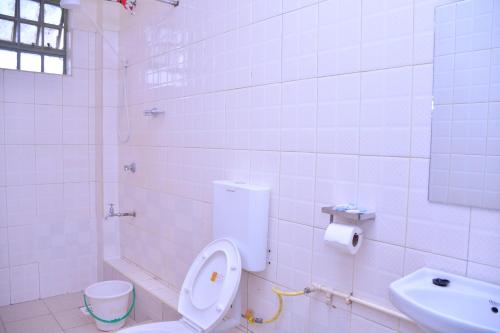 ein weißes Bad mit einem WC und einem Waschbecken in der Unterkunft Peridot Suites in Nairobi