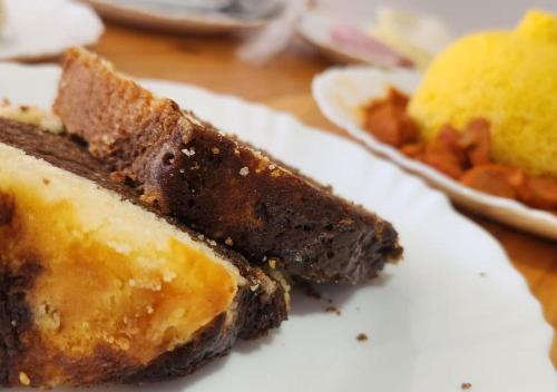 a white plate with a piece of cake on a table at BOB Suítes in Porto De Galinhas