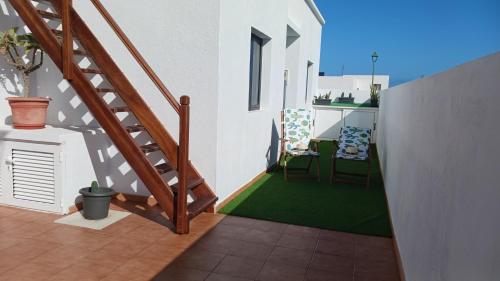 einen Balkon mit einer Treppe und einem grünen Teppich in der Unterkunft Casa Mar Azul. in Tinajo