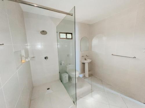 a bathroom with a glass shower and a toilet at Suite Hotel Romanos in Playas