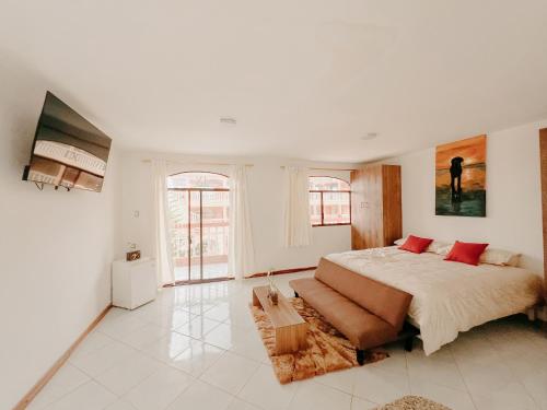 1 dormitorio con 1 cama grande y 1 sofá en Suite Hotel Romanos, en Playas