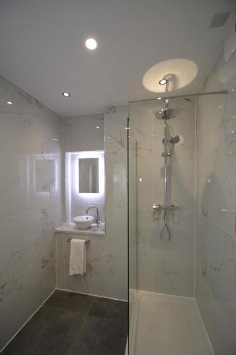 a bathroom with a glass shower and a sink at The Rugby Hotel in Rugby