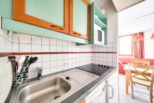 une cuisine avec un évier et un plan de travail dans l'établissement Résidence Les Chalets des Arolles - maeva Home - Studio 4 Personnes - Confort MAE-6544, à La Plagne Tarentaise