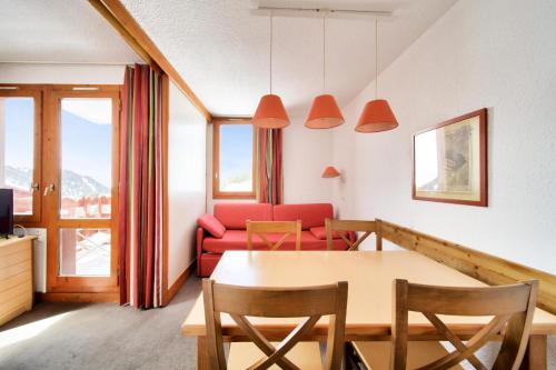 un salon avec une table et un canapé dans l'établissement Résidence Les Chalets des Arolles - maeva Home - Studio 4 Personnes - Confort MAE-6544, à La Plagne Tarentaise