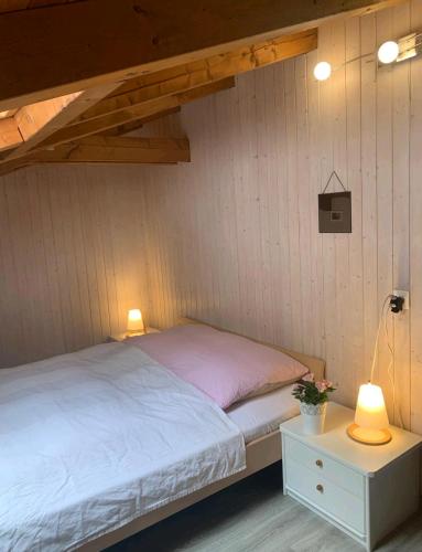Bett in einem Zimmer mit 2 Lampen und einem Tisch in der Unterkunft Chez Ninfa in Villeret