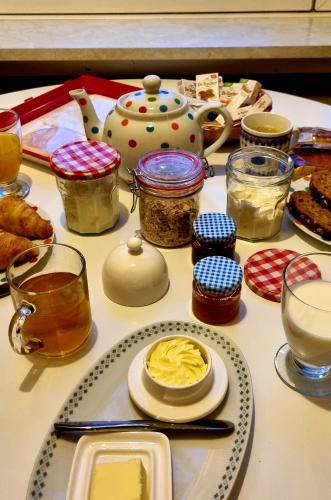 a table topped with jars and plates of food at City Farmers Lodge, a Guesthouse with a skyline view in Rural Amsterdam in Amsterdam