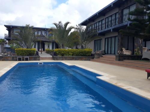 una piscina frente a una casa en Villas Rocher - Standard Suite 2B en Grand Baie