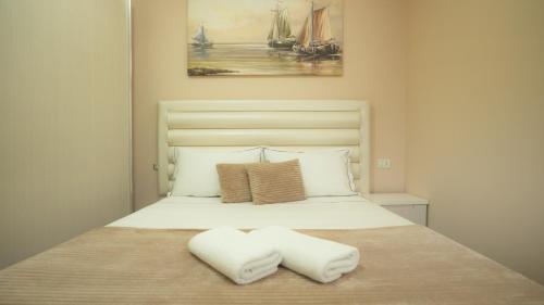 a bedroom with a bed with two pillows on it at Gent's Inn in Durrës