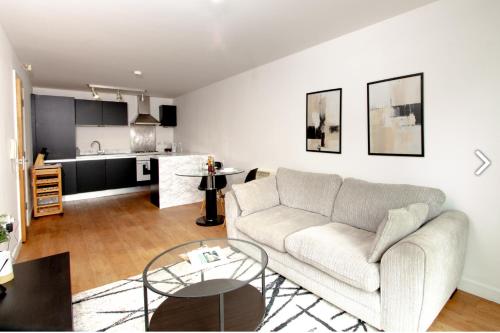 a living room with a couch and a kitchen at Chic 1Bed Apt near Liverpool CC in Liverpool