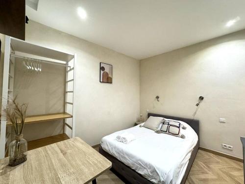 une petite pièce avec un lit et une table dans l'établissement Studio au coeur du Vieux Port avec Clim, à Marseille